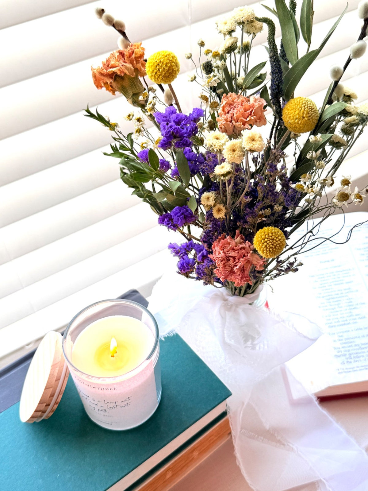 Overhead lifestyle view of the scripture candle and dried flowers
