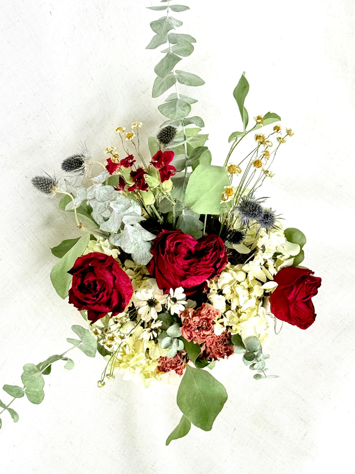 Everlasting Romance viewed from above, showing red roses, pale hydrangea, petite flowers, and greenery