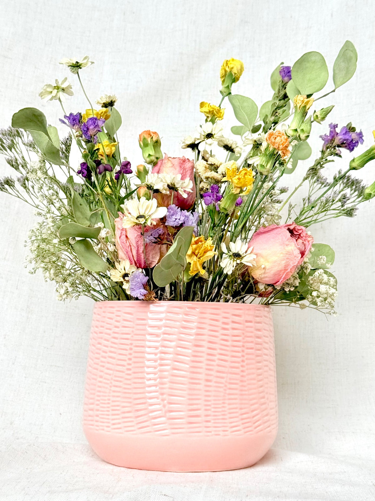 Garden Daydream dried flowers in a textured blush pink vessel, seen from the front
